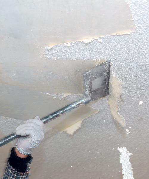 A man is painting a ceiling with a paint roller